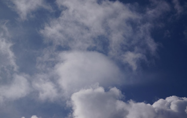 Um céu azul com nuvens e uma nuvem branca ao fundo.