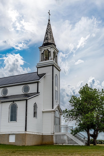 Um céu dramático sobre a torre do sino da igreja católica romana de blumenfeld em saskatchewan canadá