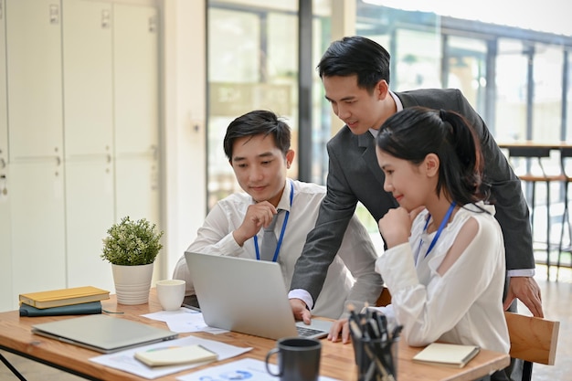 Um chefe masculino discute o trabalho, dá conselhos e verifica um novo projeto em um laptop