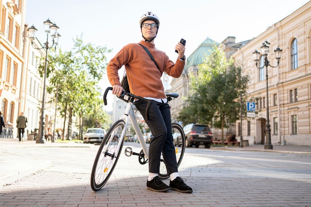 Um ciclista masculino anda de bicicleta para trabalhar na cidade O transporte ecológico é moderno