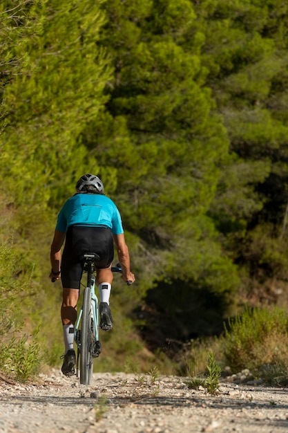 Um ciclista masculino em um passeio de bicicleta de estrada de cascalho nas montanhas da Costa Blanca Alicante Espanha