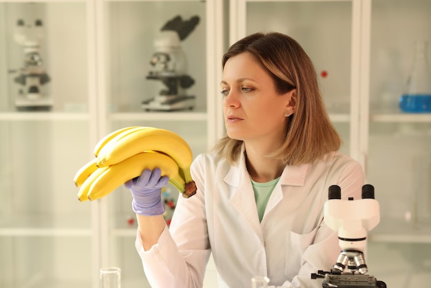 Um cientista no laboratório olha para as bananas um exame de certificação de frutas em close