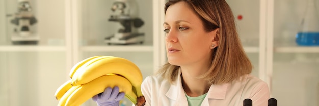 Um cientista no laboratório olha para as bananas um exame de certificação de frutas em close