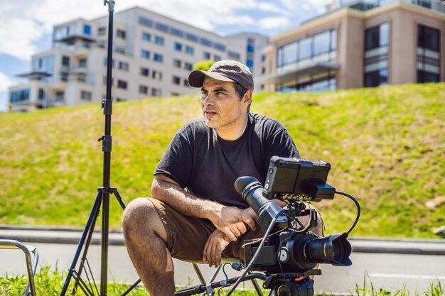 Um cinegrafista profissional prepara uma câmera e um tripé antes de fotografar.