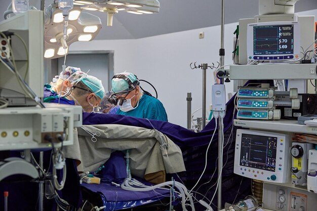 Um cirurgião com assistentes realiza uma operação em um hospital moderno. Operação de execução de equipe médica.