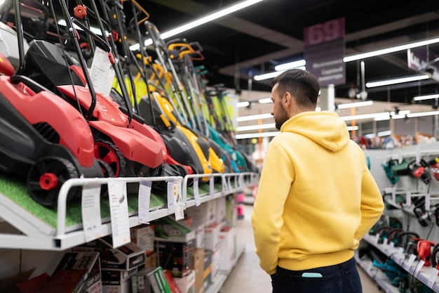 Um cliente examina novos modelos de cortadores de grama em uma loja de produtos elétricos para jardineiros e