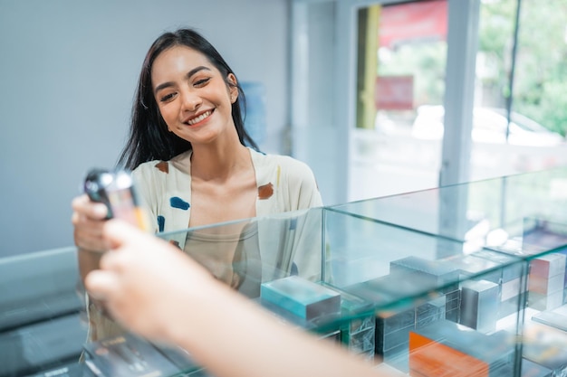 Foto um cliente lindo sorrindo enquanto escolhe os mods de vape ajudado pelo comerciante masculino