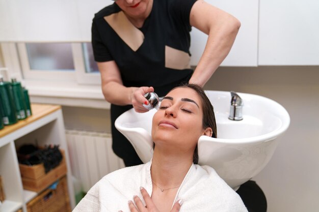 Foto um cliente sereno desfruta de uma lavagem do couro cabeludo antes da terapia com células estaminais
