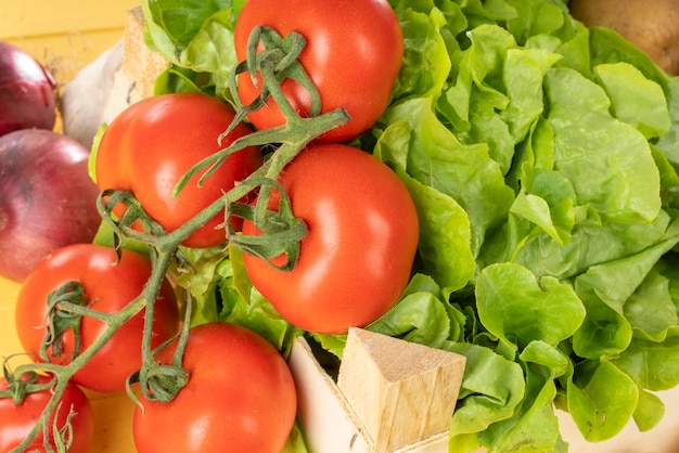 Um close de tomates e salada numa pequena caixa de madeira
