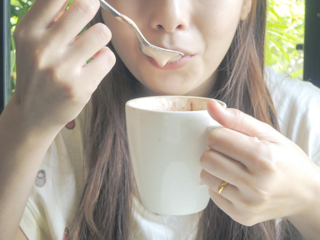 Um close de uma rapariga a beber café.