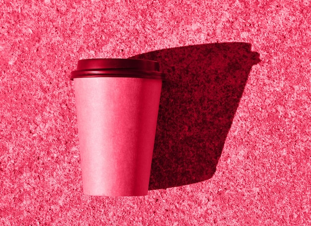 Um close de uma xícara de café descartável de papelão marrom Um lugar para o seu design de embalagem Cor da imagem colorida do ano 2023 viva magenta