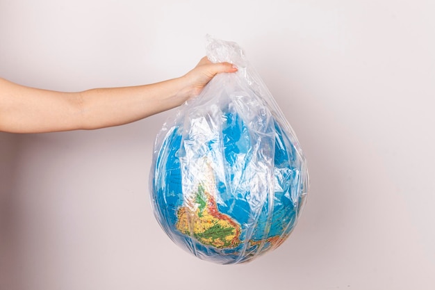 Foto um close do planeta terra na forma de um globo em um saco plástico o conceito de salvar o plano
