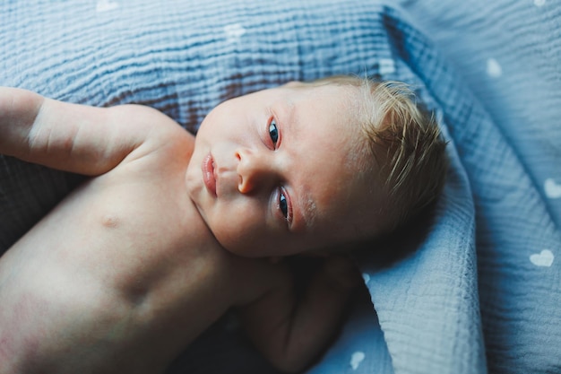 Um close do rosto de um bebê recém-nascido Um recém-nascido está olhando para a câmera Olhos abertos de um bebê recém-nascido
