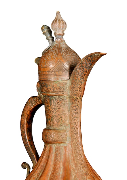 Um close-up de um jarro de cobre antigo com perseguição artística e gravura em um fundo branco