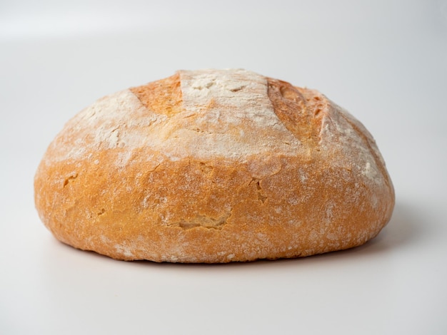 Um close-up de um pão de trigo redondo delicioso e fresco inteiro em um fundo branco Itens isolados assando a vista lateral