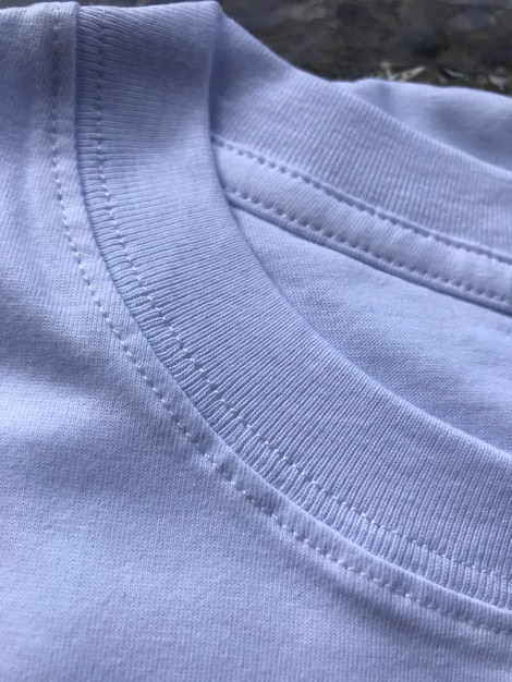 Foto um close-up de uma camisa branca com uma borda costurada.