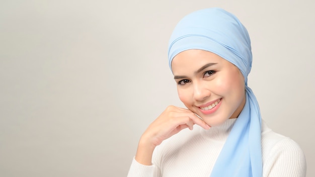 Um close-up de uma jovem mulher muçulmana bonita com hijab isolado no estúdio de fundo branco, conceito de cuidados com a pele de beleza muçulmana.