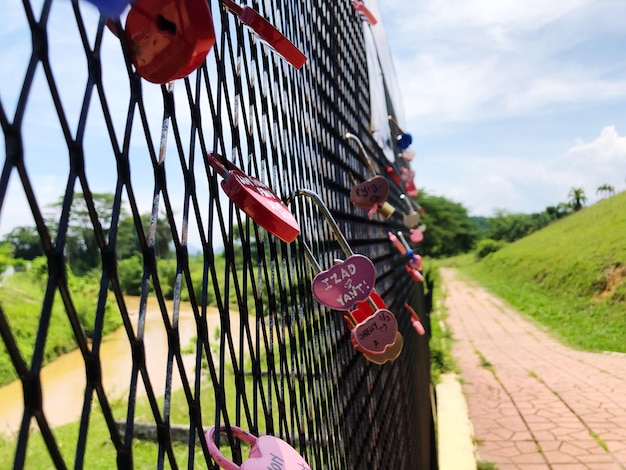 Um close-up do amor bloqueia a cerca contra o céu