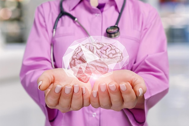 Um close-up do jovem médico segurando o modelo de imagem do cérebro dentro de uma gaiola protetora nas palmas das mãos no fundo desfocado do quarto do hospital