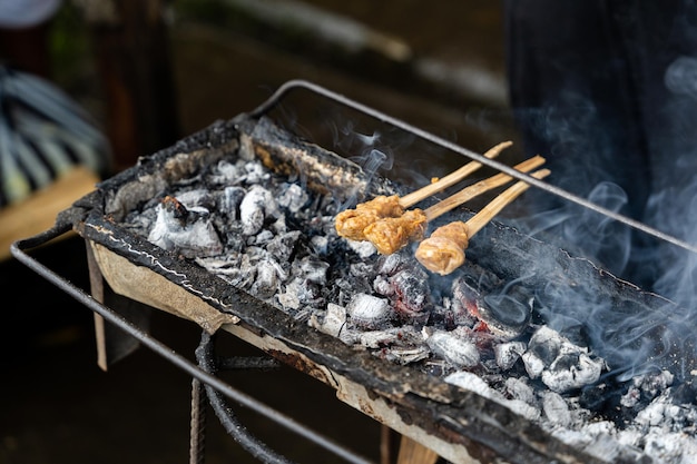 Um close-up do tradicional espeto de satay balinês cozido em carvão horizontal