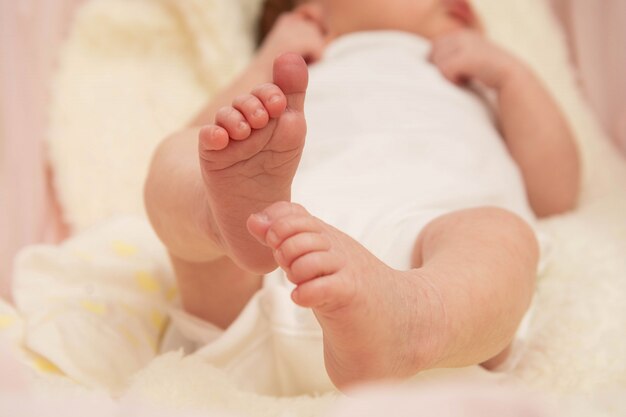 Um close-up minúsculos pés do bebê. Conceito de puericultura, segurança e educação.