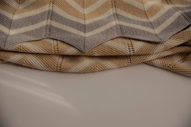 Um cobertor listrado está sobre uma mesa com a palavra lã.