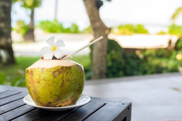 Foto um coco na mesa de madeira em um bungalow aconchegante com jardim tropical verde na ilha de phi phi, na tailândia