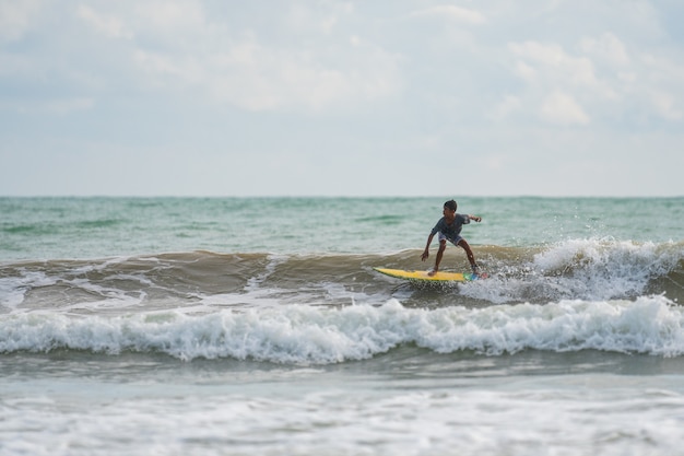 Um com um surf em suas mãos na costa do mar