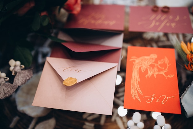 Um conceito de casamento. Convite e itens, envelopes de papel de cores diferentes sobre a mesa