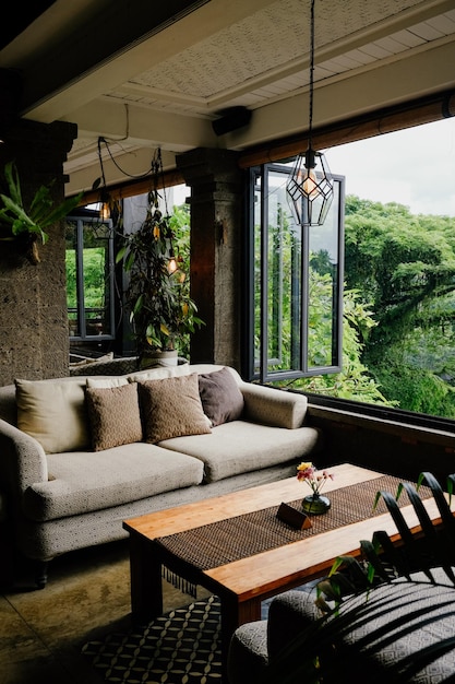 Um confortável salão com sofá e mesa de madeira com vista para a vegetação