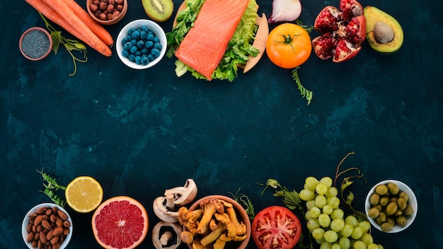 Um conjunto de alimentos saudáveis em uma mesa de pedra Peixe legumes frutas nozes bagas cogumelos Vista superior Espaço livre para texto