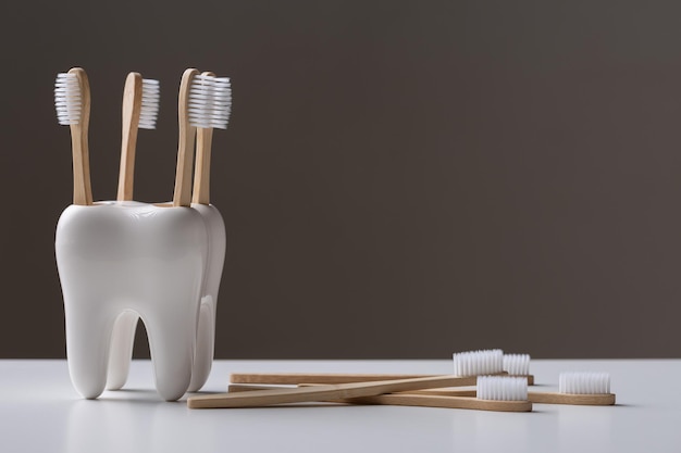 Um conjunto de escovas de dentes de madeira de bambu ecológicas em um suporte em forma de dente