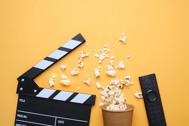 Um conjunto de filmes está em uma mesa e o controle remoto está sendo usado para assistir um filme