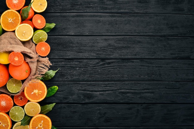 Um conjunto de frutas cítricas laranja tangerina toranja limão Em um fundo de madeira Vista superior Copiar espaço