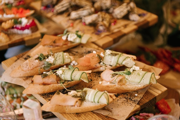 Um conjunto de lanches italianos para um buffet Uma variedade de queijos frios bruschetta pepinos em conserva tomates em um fundo de madeira