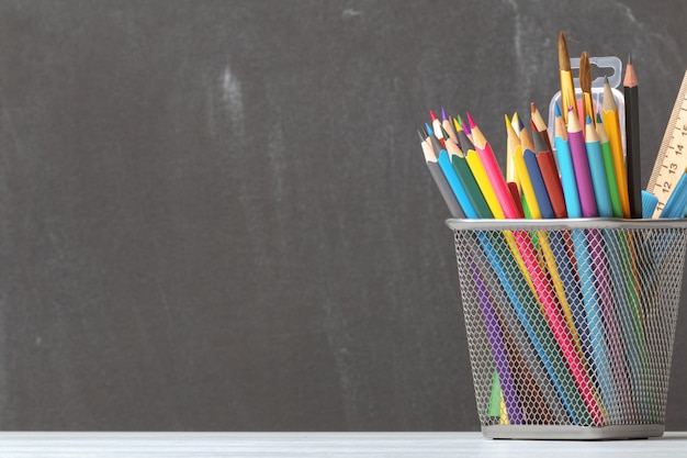 Um conjunto de lápis, pincéis, tintas no fundo da diretoria da escola.