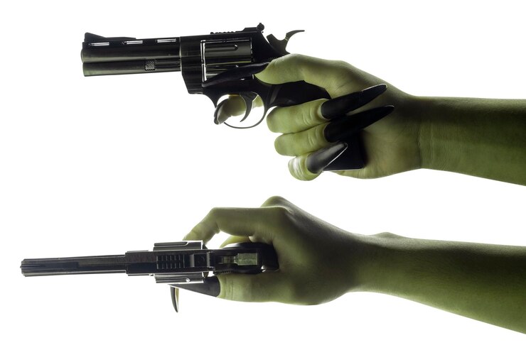 Foto um conjunto de mãos de bruxas segurando uma arma a cor da mão é verde mão de zumbi malvado ou monstro