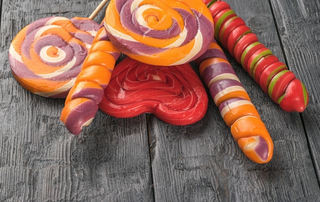 Um conjunto de pirulitos coloridos em palitos em uma mesa de madeira conceito mínimo de doce vida e amor