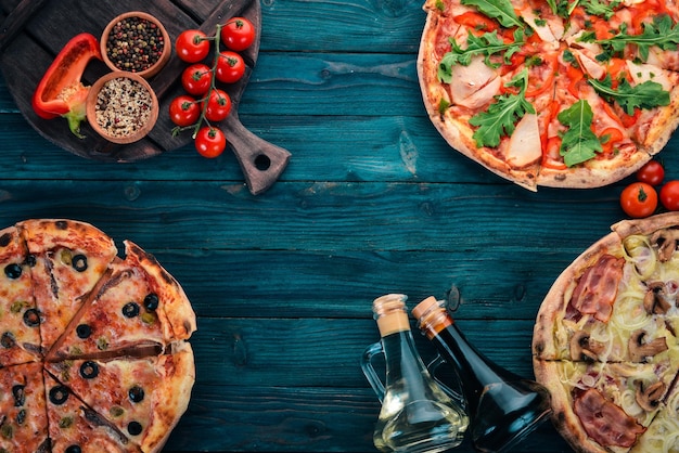 Um conjunto de pizza Em um fundo preto de madeira Espaço livre para texto Vista superior