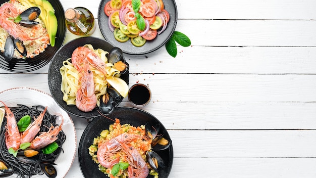 Um conjunto de pratos de frutos do mar em um fundo branco Macarrão bulgur arroz cuscuz Vista superior Espaço livre para o seu texto