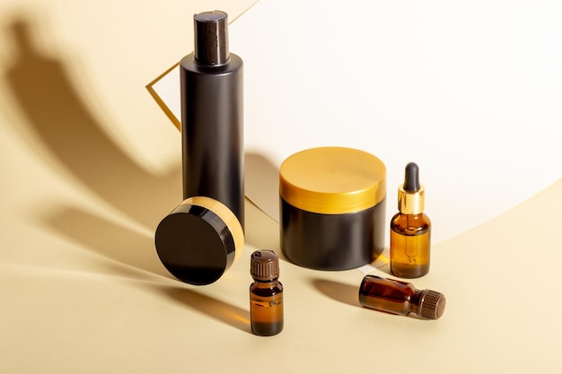 Um conjunto de produtos cosméticos de cor escura sobre fundo bege com sombras duras Cosméticos orgânicos naturais