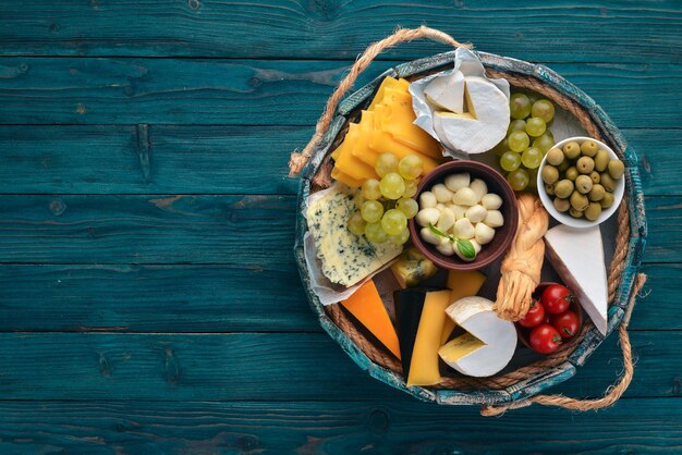 Um conjunto de queijo em uma caixa de madeira Parmesão Mamasam Mussarela Brie Feta Vista superior Em um fundo de madeira Espaço livre para o seu texto