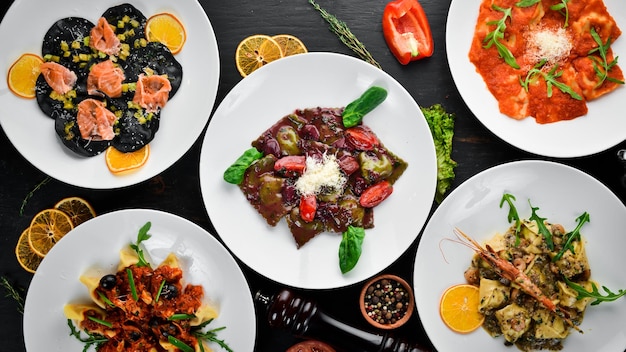 Um conjunto de ravioli e bolinhos com carne e frutos do mar em um fundo de madeira Vista superior Espaço para cópia grátis