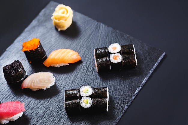 Um conjunto de rolos de sushi diferentes com caviar em fundo preto