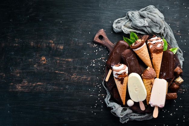 Um conjunto de sorvete com nozes de chocolate e geléia Em um fundo preto Vista superior Espaço para cópia grátis