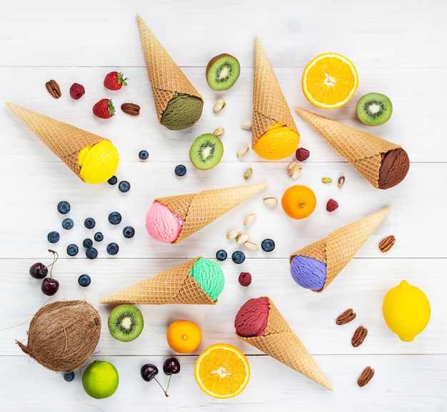 Um conjunto de sorvetes de diferentes tipos com frutas e bagas em uma mesa de madeira