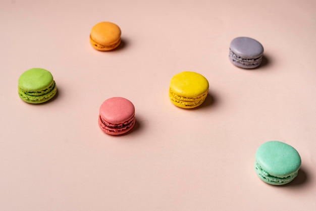 Um conjunto multicolorido de biscoitos de macaroons franceses em fundo pastel