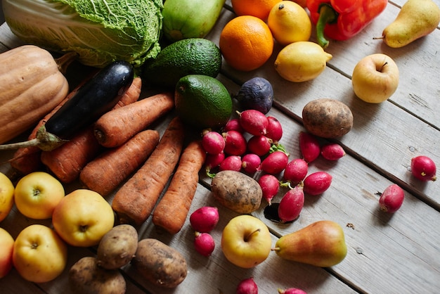 Um conjunto saudável de produtos consistindo de vegetais e frutas sobre a mesa de madeira closeup