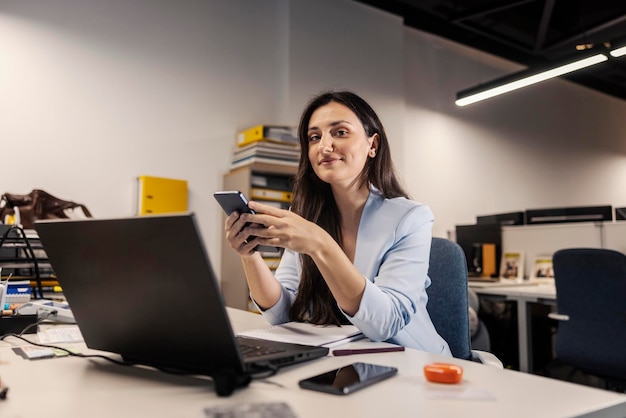 Um conselheiro financeiro está sentado no escritório e usando um telefone no escritório