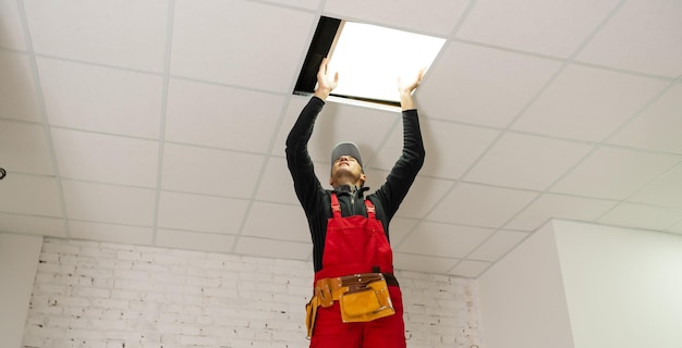 um construtor substituindo o painel do teto, trabalhando, armstrong.